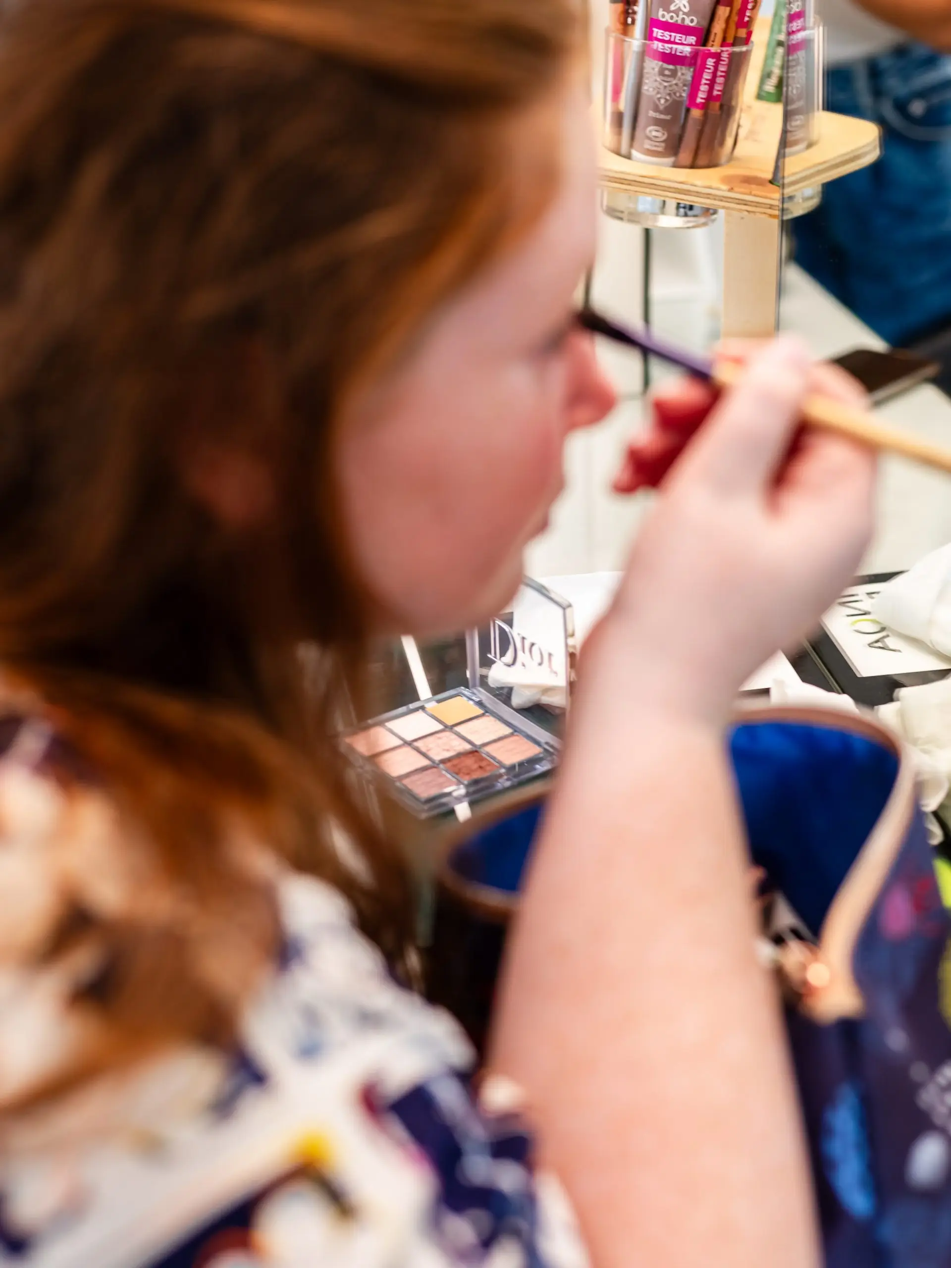 La témoin de la mariée se maquille dans le salon de coiffure à Niort.