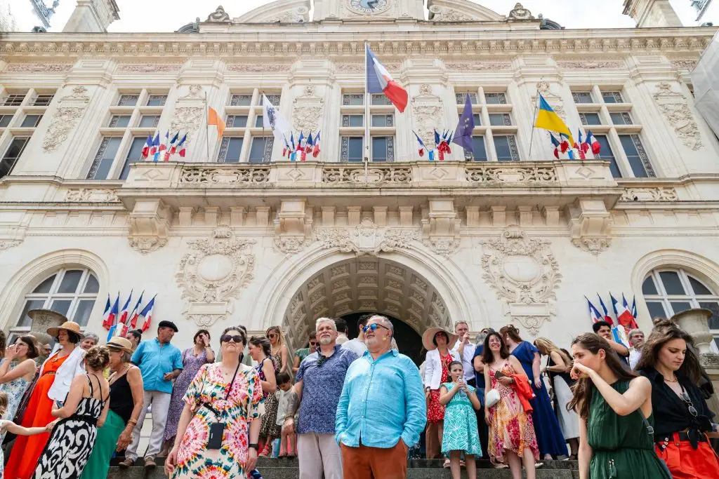Les invités regardent les mariés s'échapper au loin, sur le parvis de la mairie de Niort.