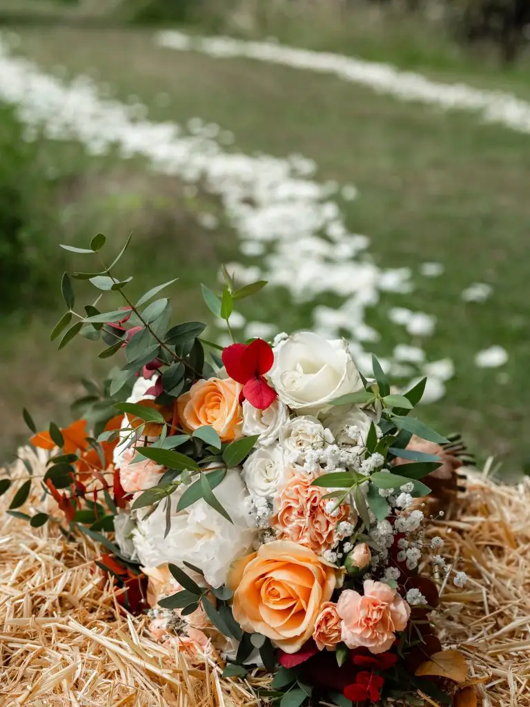 Bouquet de la mariée posé sur une botte de foin.