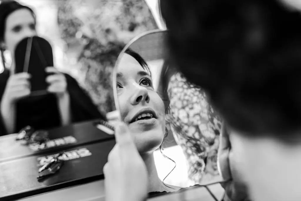 Reflet du sourire de la mariée alors qu'elle se découvre après les préparatifs.