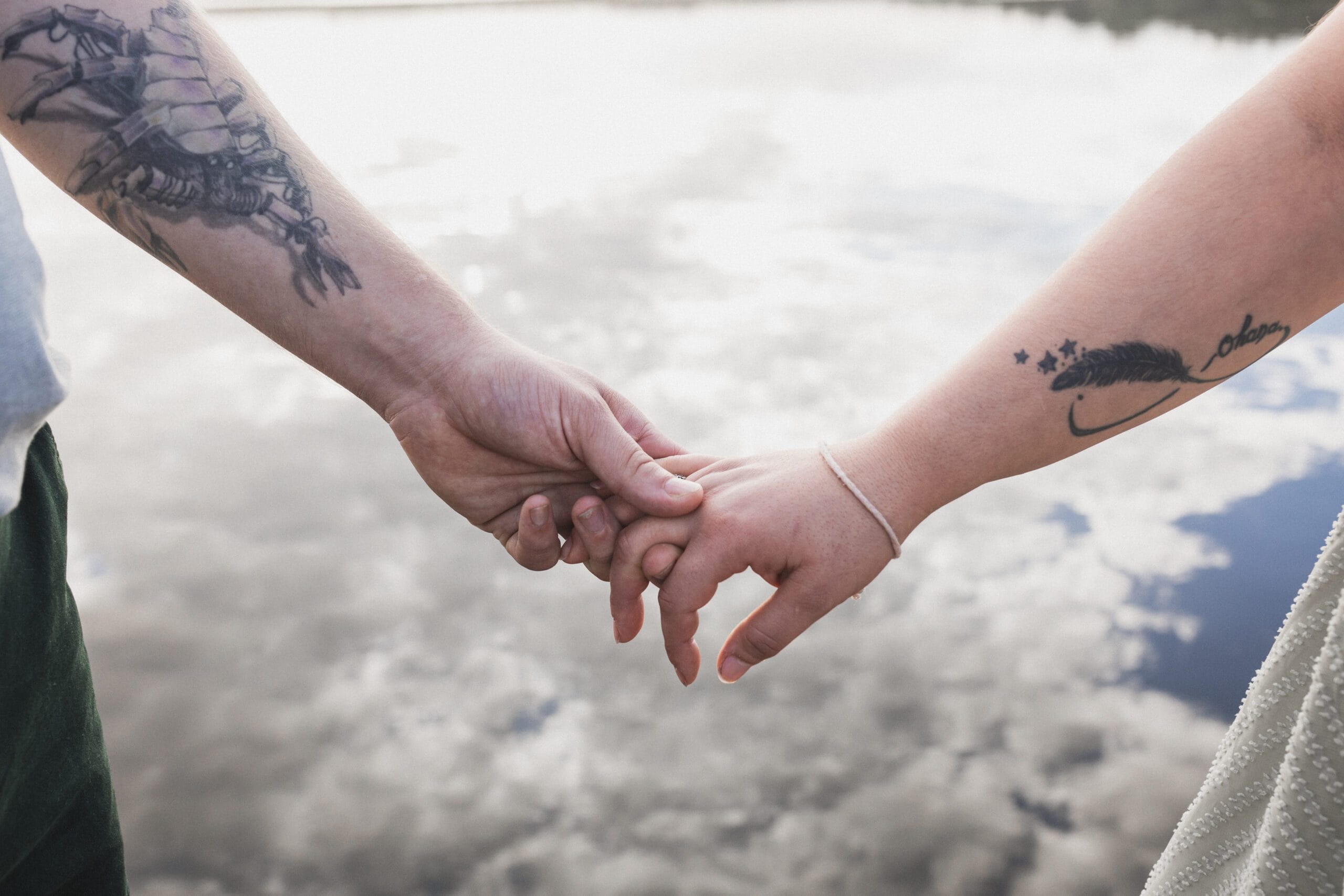 Détails des mains enlacées des fiancés sur le ponton du lac d'Azur à Soustons dans les Landes