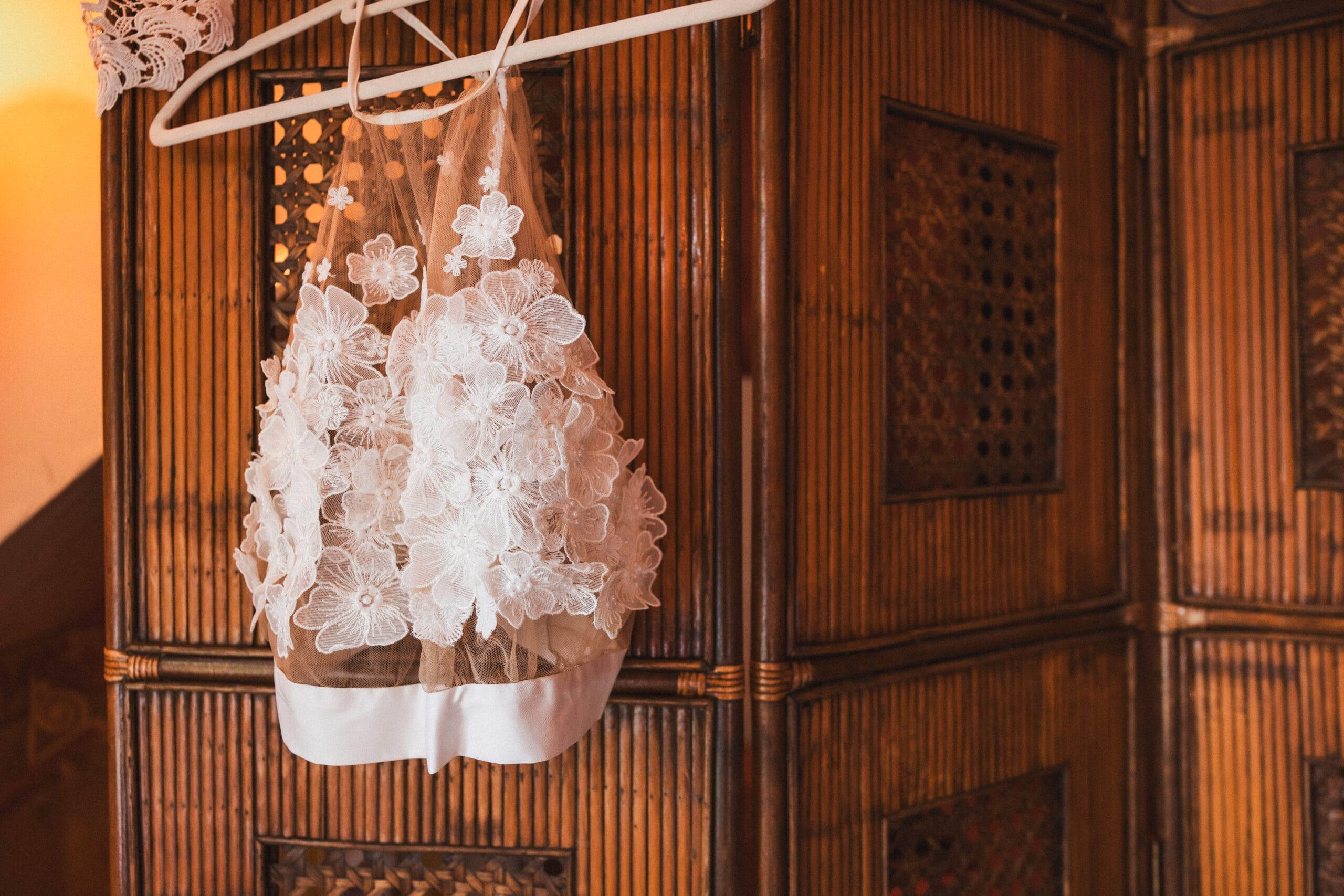 Haut en dentelle de la robe de la mariée suspendu à un paravent