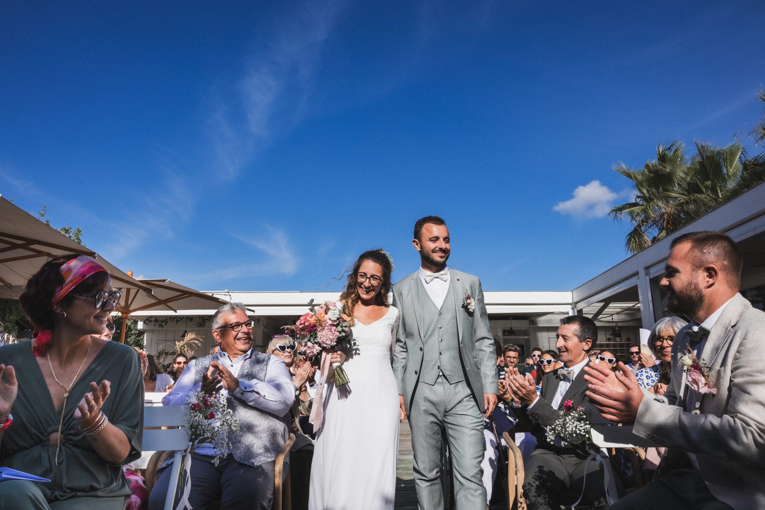 Les mariés cheminent le long de l'allée avant le début de leur cérémonie laïque à la Beach House d'Anglet, au Pays Basque, par une photographe mariage Landes