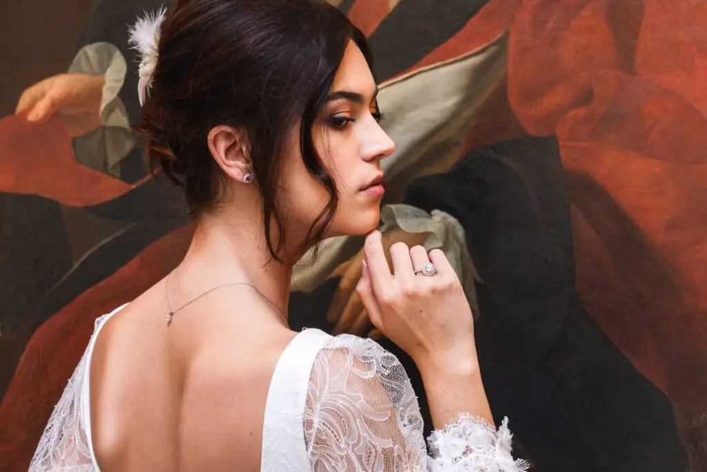 Solène prend la pose pour mettre en valeur les bijoux et le dos nu de la robe de mariée lors du shooting