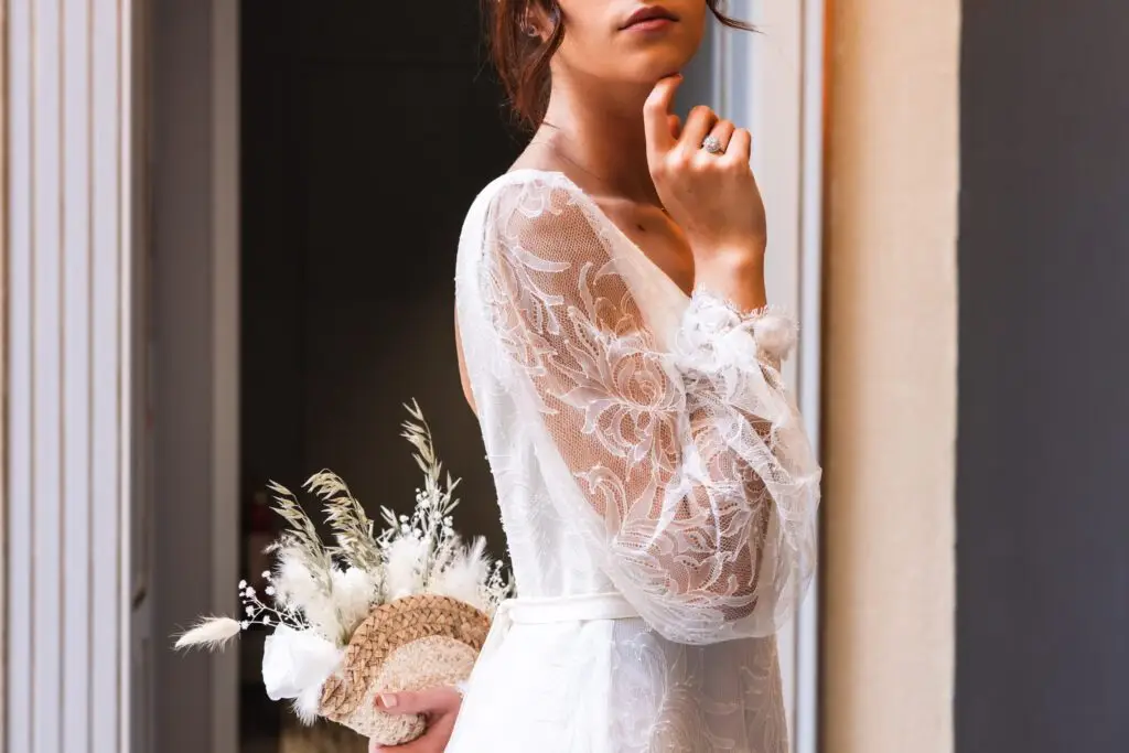 Détails de la dentelle de la robe, de la composition florale et des bijoux pendant le shooting à Bordeaux