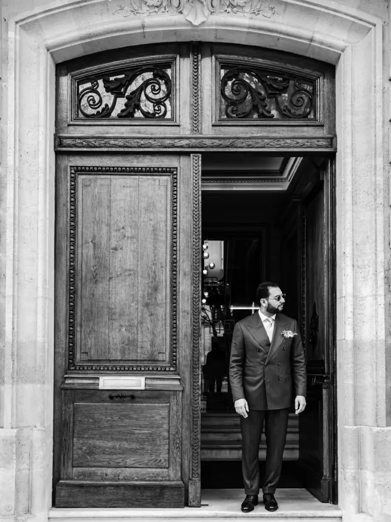Nidal prend la pose dans l'entrée des Villas Foch à Bordeaux avec son costume Sartore Tailoring