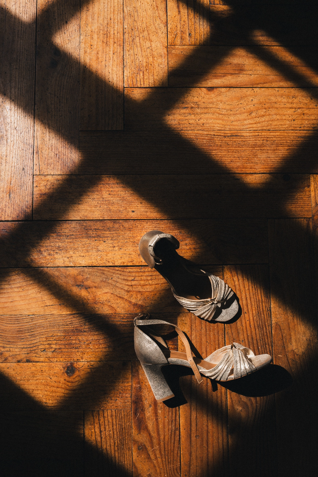 Les chaussures de la mariée gisent sur le sol dans un quadrillage de rayons de soleil dans les Landes