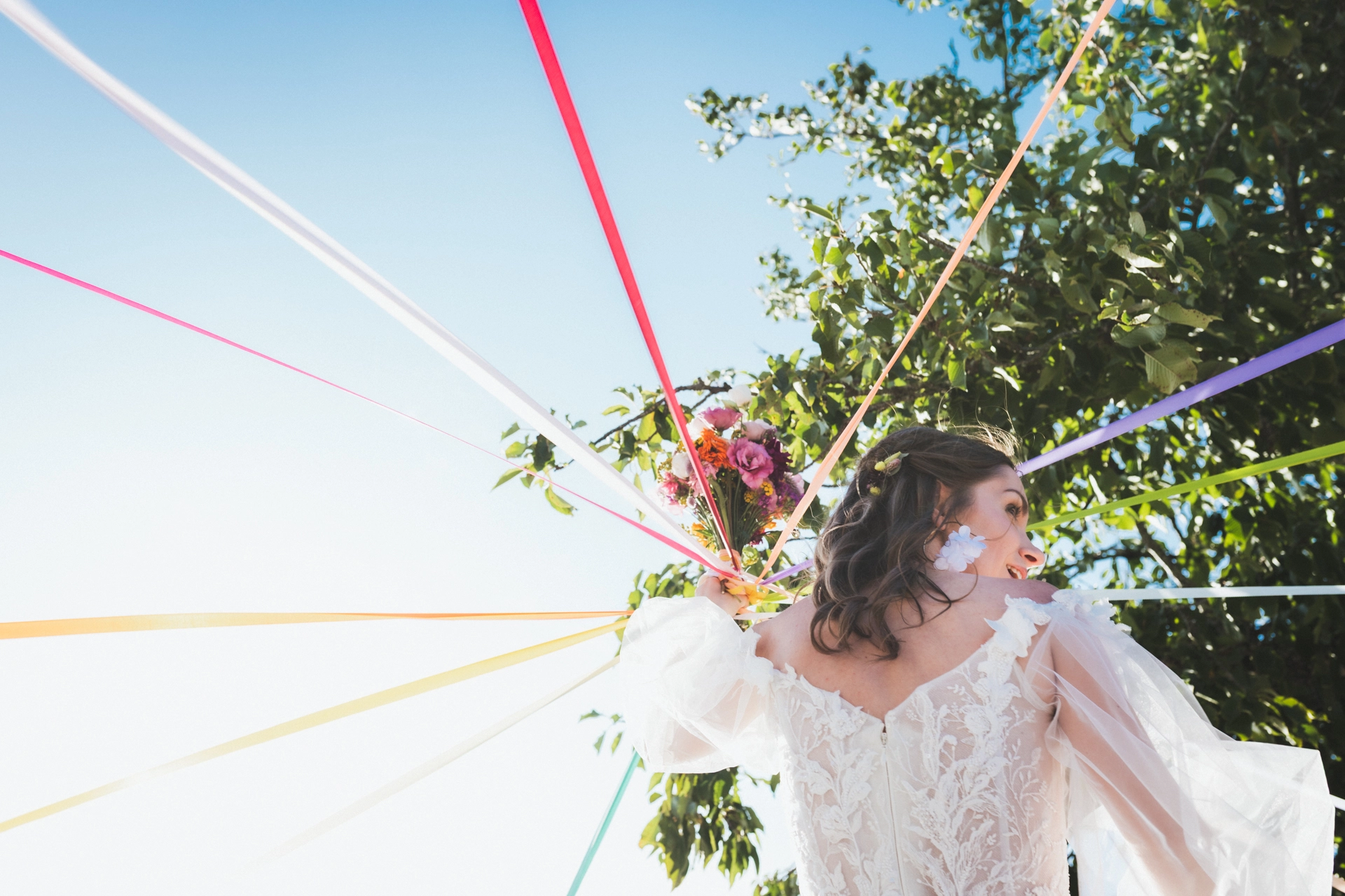 Jeu des rubans effectué par la mariée lors d'un cocktail de mariage au Domaine de Badine en Gironde, immortalisé par une photographe de mariages colorés.