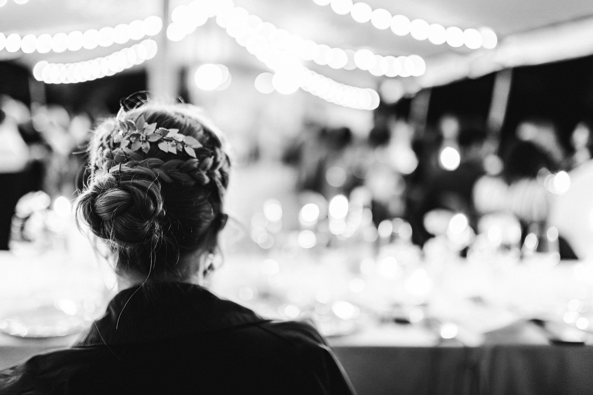 Portrait de la mariée de dos, pendant le repas, alors qu'elle écoute les discours de ses témoins au Château Larteau en Gironde
