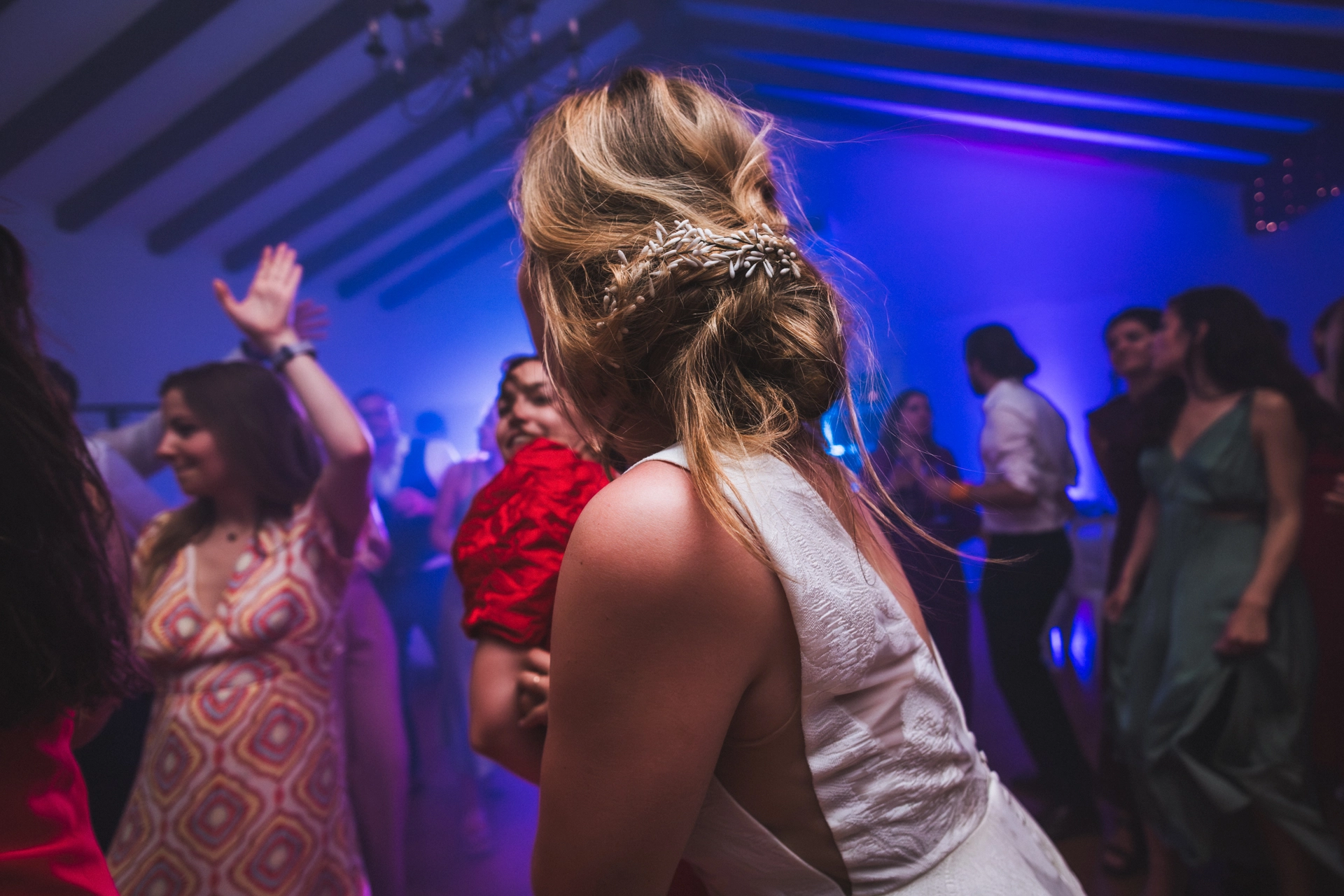 De dos, la mariée danse avec énergie sur le dancefloor, lors d'un mariage au Pays Basque réalisé par une photographe de mariages colorés