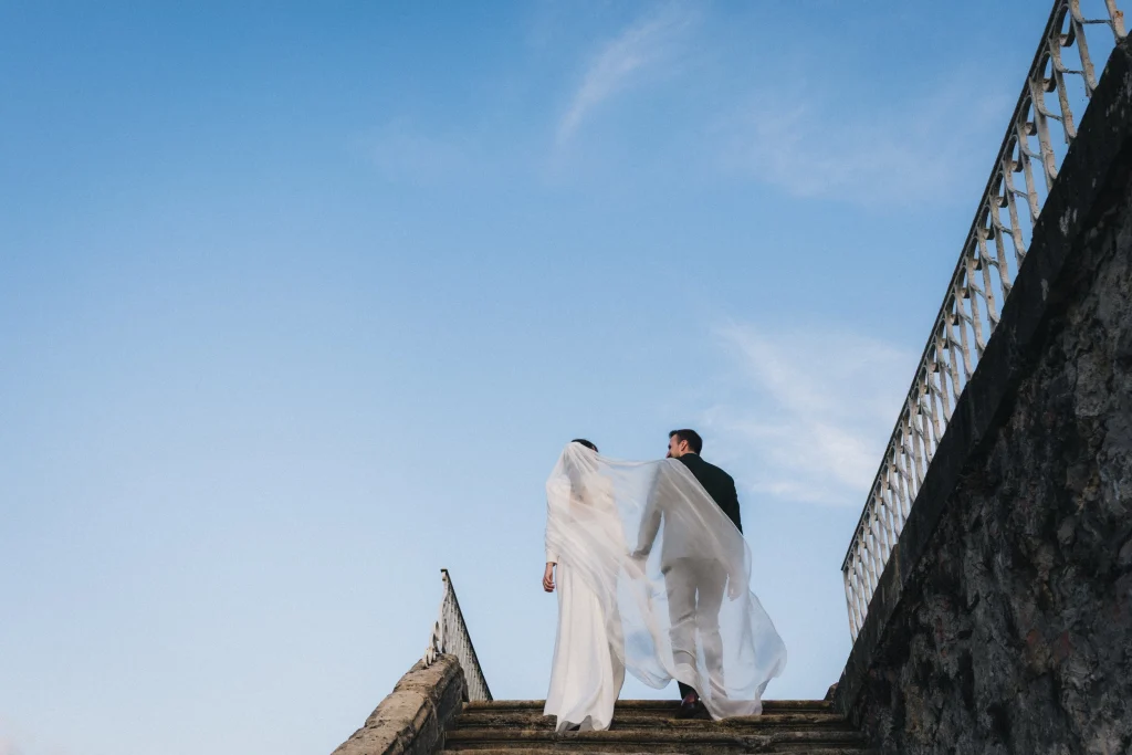 Les mariés grimpent l'escalier du château de Campet dans les Landes, durant leur séance couple.