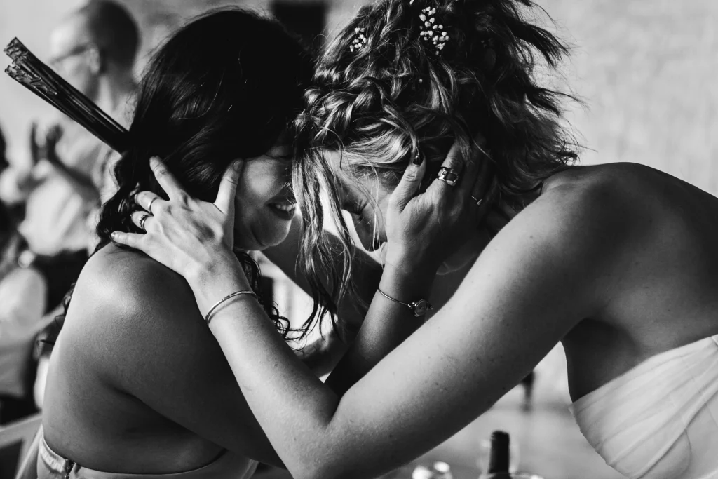 Après un discours émouvant de sa demoiselle d'honneur, la mariée lui prend la tête dans les mains et pose délicatement son front contre le sien, signe d'amour et de gratitude.