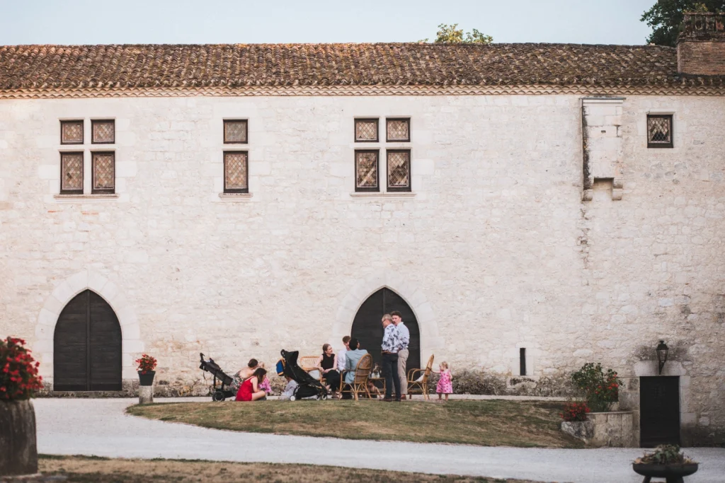 Mariage au Château Sainte Foy d'Anthe en Lot-et-Garonne, où des invités se prélassent pendant le cocktail sur les transats devant la bâtisse principale.