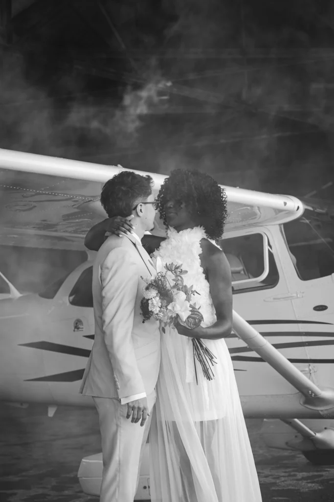 Les mariés s'enlacent devant un avion dans l'aérodrome de Sarlat en Dordogne, juste avant de décoller.