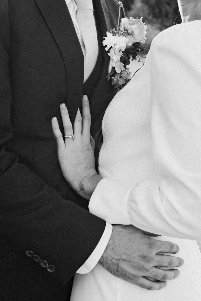 Mariage dans les Landes au Château de Campet, où les mariés se tiennent enlacer l'un contre l'autre. Seules leurs mains sont visibles.