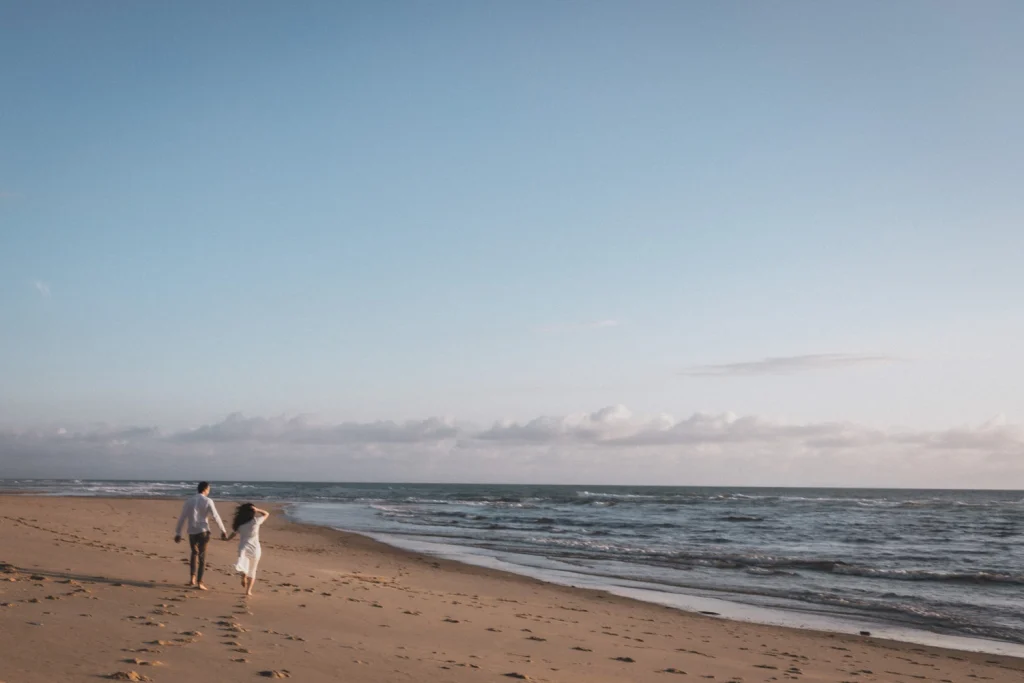 Les fiancés s'élancent en courant vers l'océan, alors que le soleil se couche sur une plage des Landes.