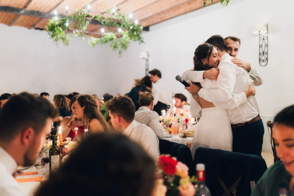 Câlin attendrissant entre le frère du marié et le couple suite à son discours pendant le repas de mariage dans les Landes au château de Campet.