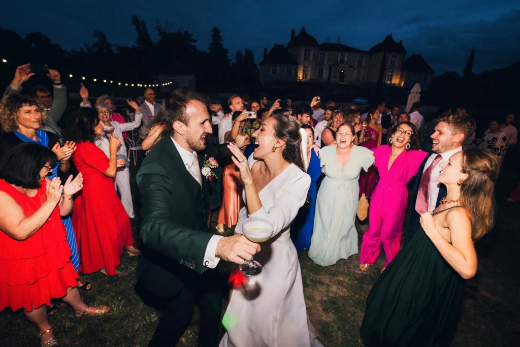 Alors que la nuit tombe et le cocktail se termine, les mariés dansent au milieu de leurs invités lors d'un mariage dans les Landes.