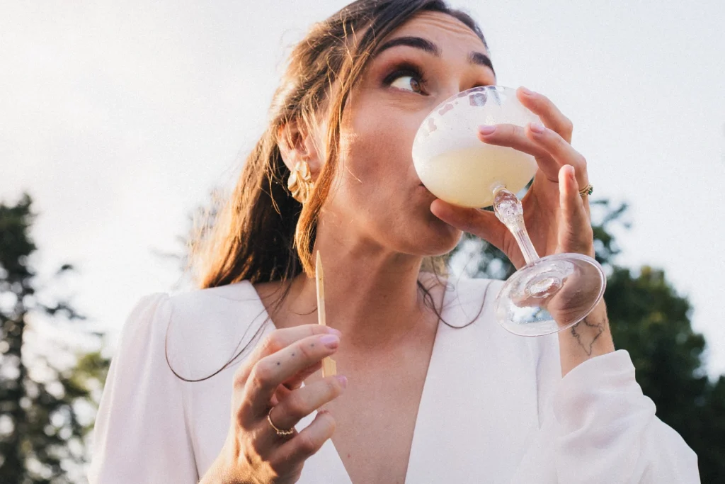 Portrait de la mariée qui boit un verre lors de son cocktail de mariage dans les Landes.