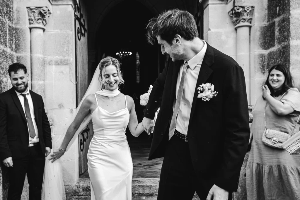 Les mariés sortent en riant de leur cérémonie religieuse, lors d'un mariage à Bordeaux.