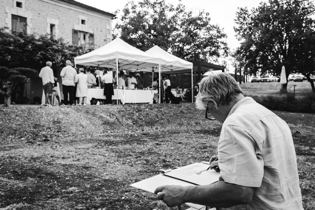 Un aquarelliste dessine une scène du cocktail de mariage en Dordogne.
