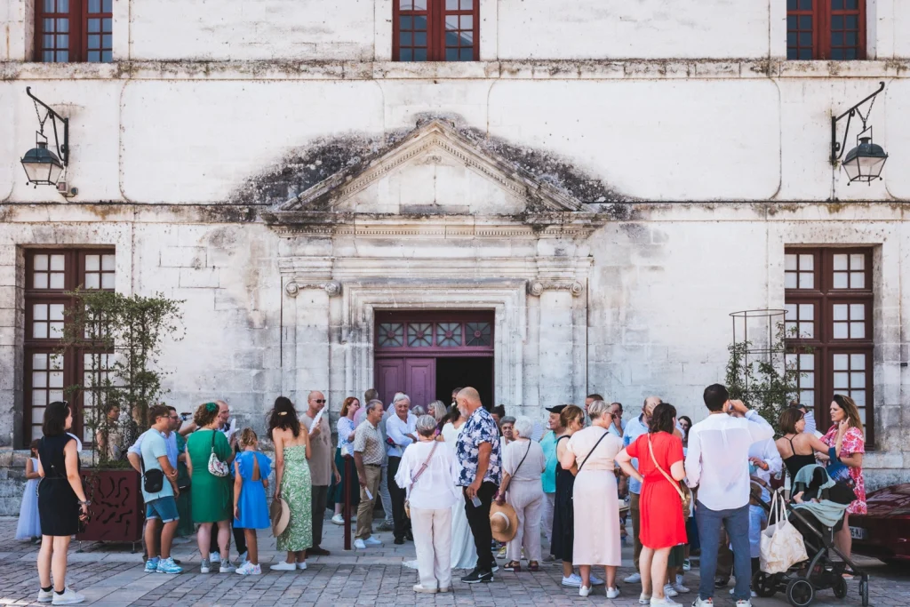 Lors d'un mariage à Brantôme en Périgord en Dordogne, les invités attendent patiemment les mariés devant la mairie.