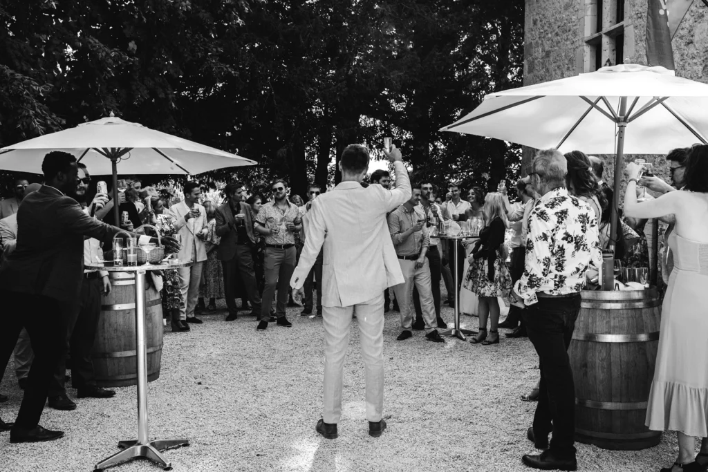 Le marié lève son verre face à tous ses invités, lors de son cocktail de mariage en Lot-et-Garonne au château Sainte-Foy d'Anthe.