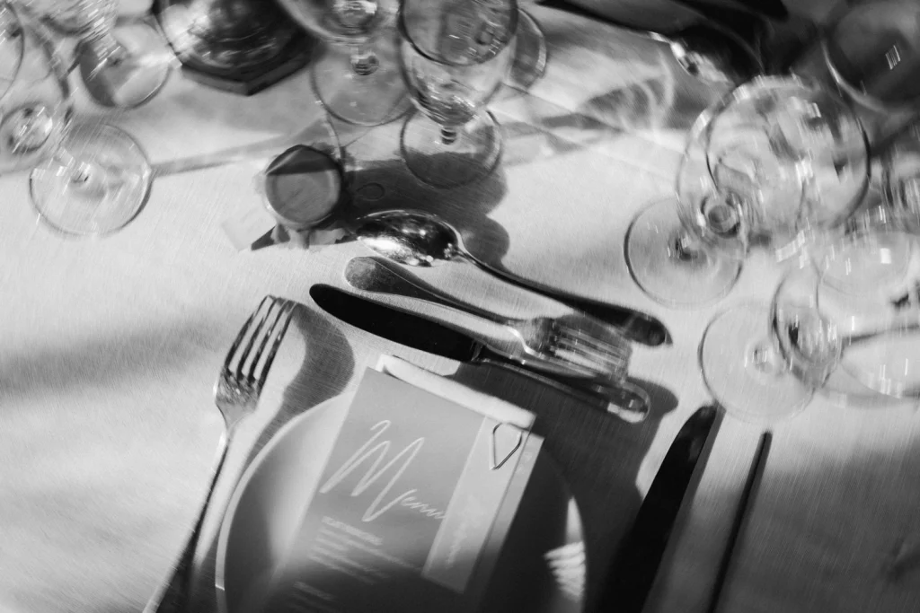 Détail de la vaisselle et de la table dans la salle de réception pour un repas de mariage au Château de Campet dans les Landes.