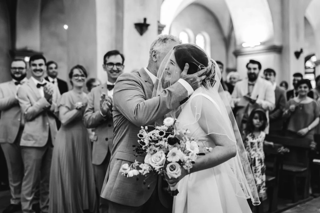 Cérémonie religieuse dans les Landes où le père accompagne sa fille jusqu'à l'autel et l'embrasse sur la joue.