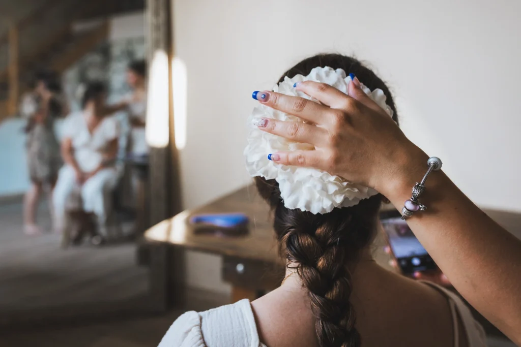 Préparatifs de la mariée qui se fait coiffer à l'espagnol par une de ces demoiselles d'honneur, lors d'un mariage au domaine Le Herre en Gironde.