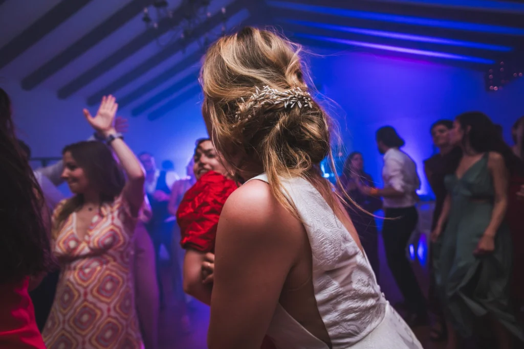 Portrait de la mariée de dos sur le dancefloor, avec son chignon qui se défait à force de danser, lors de son mariage au Pays Basque.
