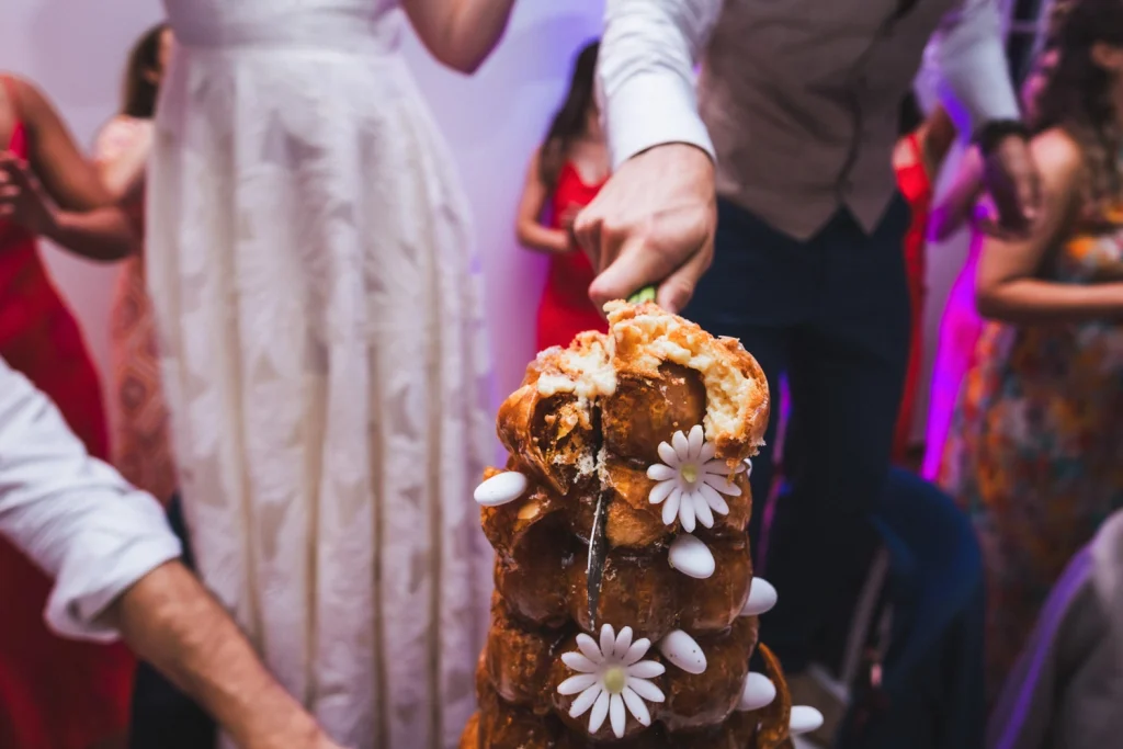 Découpage au couteau de la pièce montée fleurie lors d'un mariage au Pays Basque.