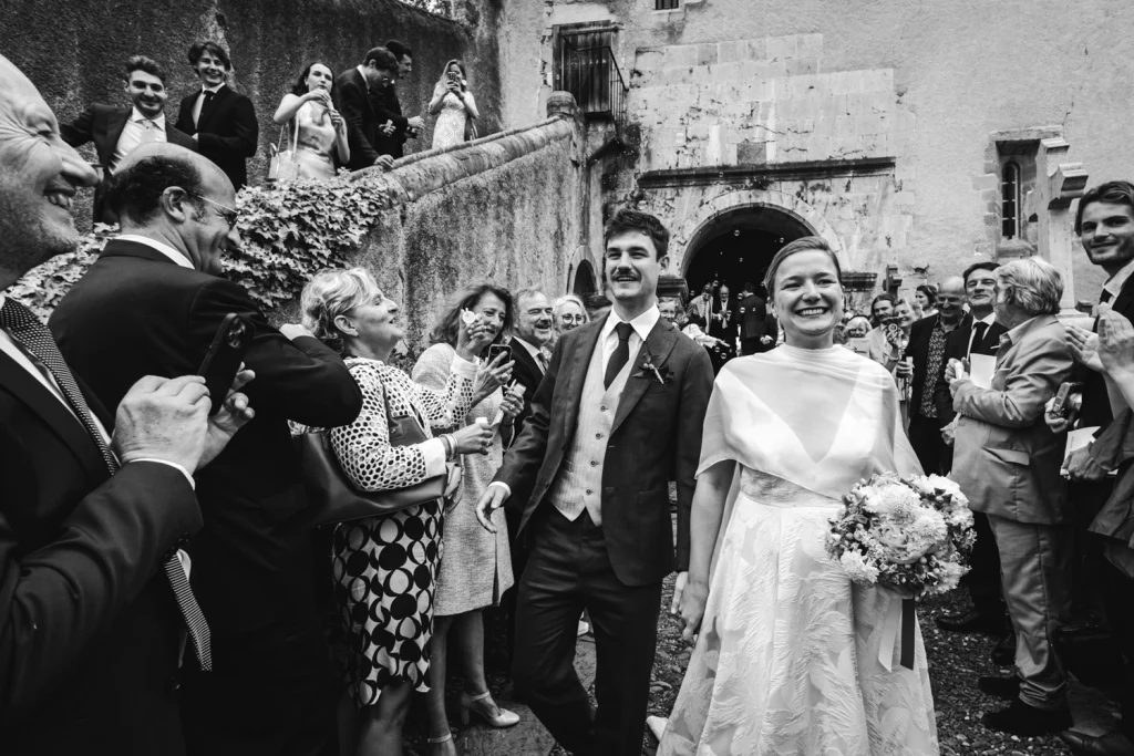 Les mariés sortent de l'église sous les applaudissement et les cris de joie de leurs invités, lors de leur mariage à Espelette au Pays Basque.