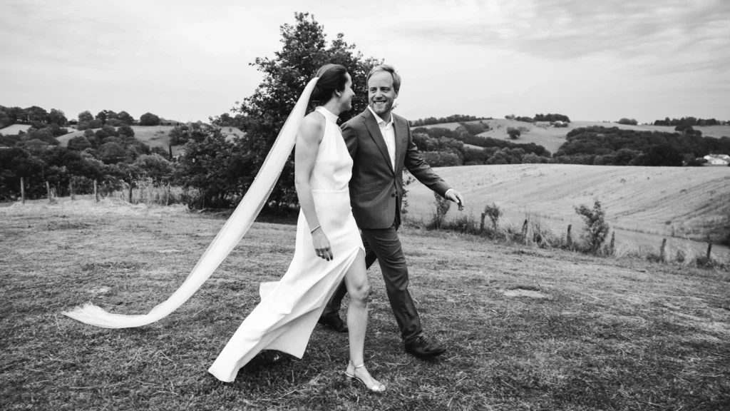 Les mariés marchent en se regardant et en se tenant la main pour se diriger vers le cocktail au domaine Etxezahar au Pays Basque.