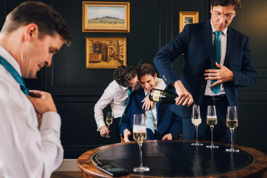 Préparatifs des mariés et témoins trinquant au champagne avant un mariage au château Larteau en Gironde