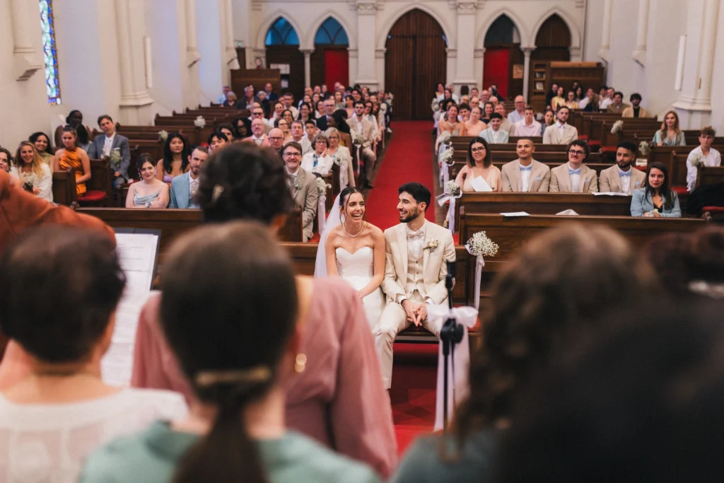 Cérémonie religieuse au temple de Pau dans les Pyrénées Atlantiques, où les mariés rient de bonheur en écoutant une chanson composée par leurs proches.