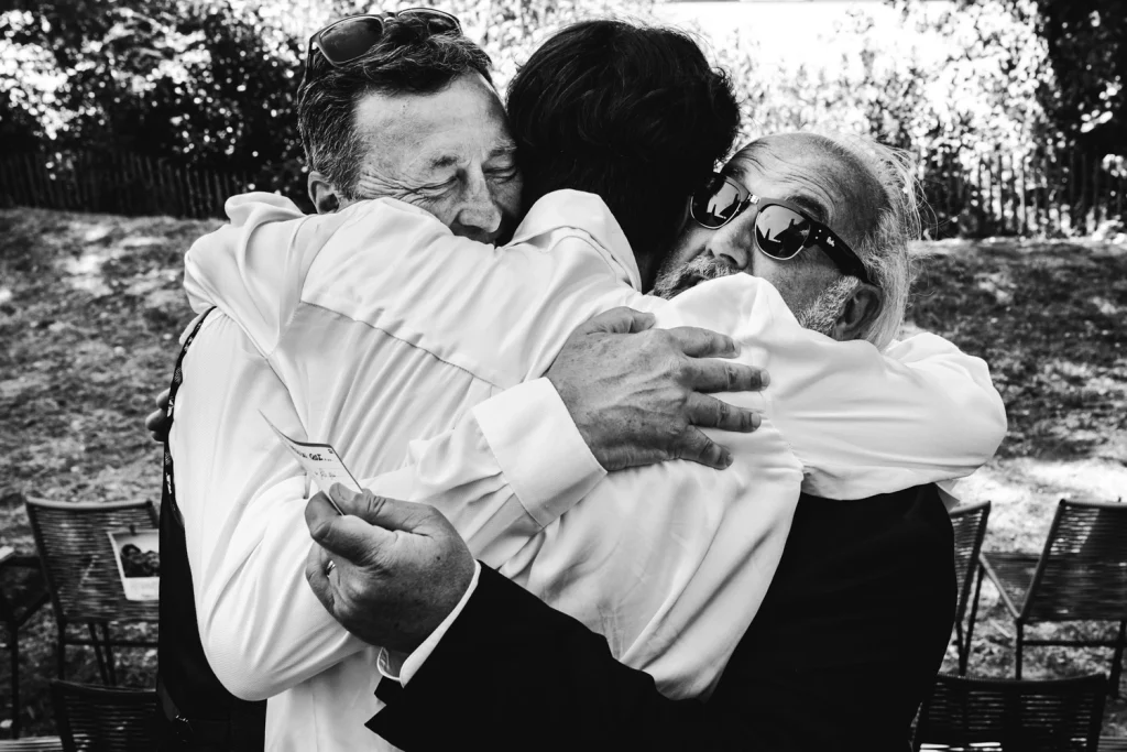 Câlin attendrissant entre le marié, son père et son beau-père, à l'issue de la cérémonie laïque à Bordeaux.
