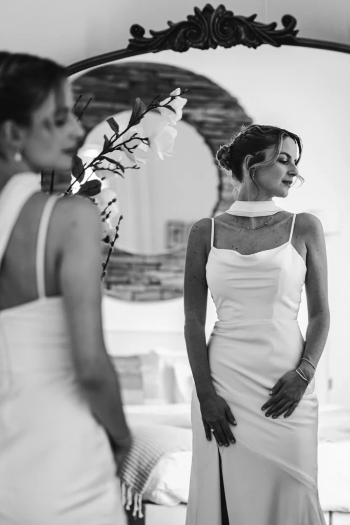 La mariée observe son reflet de le miroir à la fin de ses préparatifs de mariage à Bordeaux.