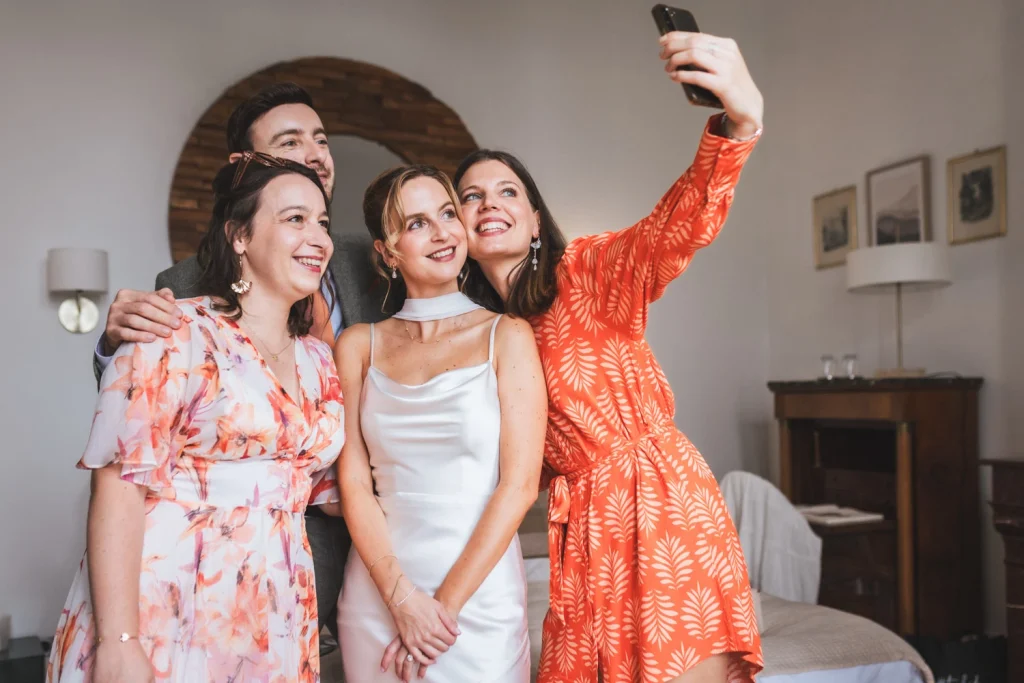 La mariée et ses témoins se prennent en photo avec leur téléphone à la fin des préparatifs de la mariée au château Larteau en Gironde.
