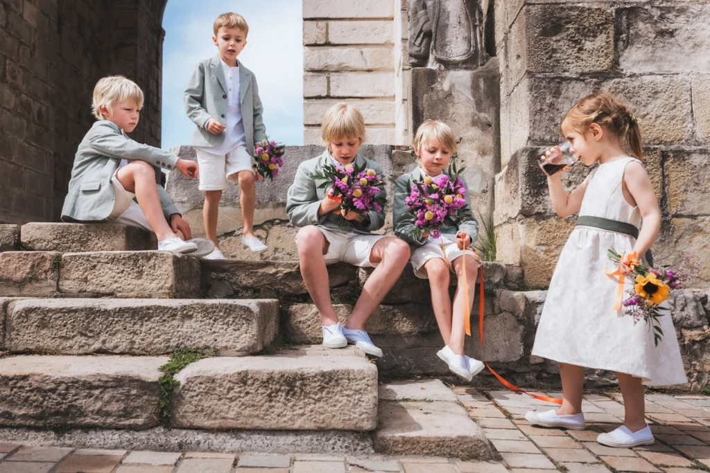 Durant la pause rafraîchissement, les enfants d'honneur s'assoient sur les marches de l'église au Pays Basque.