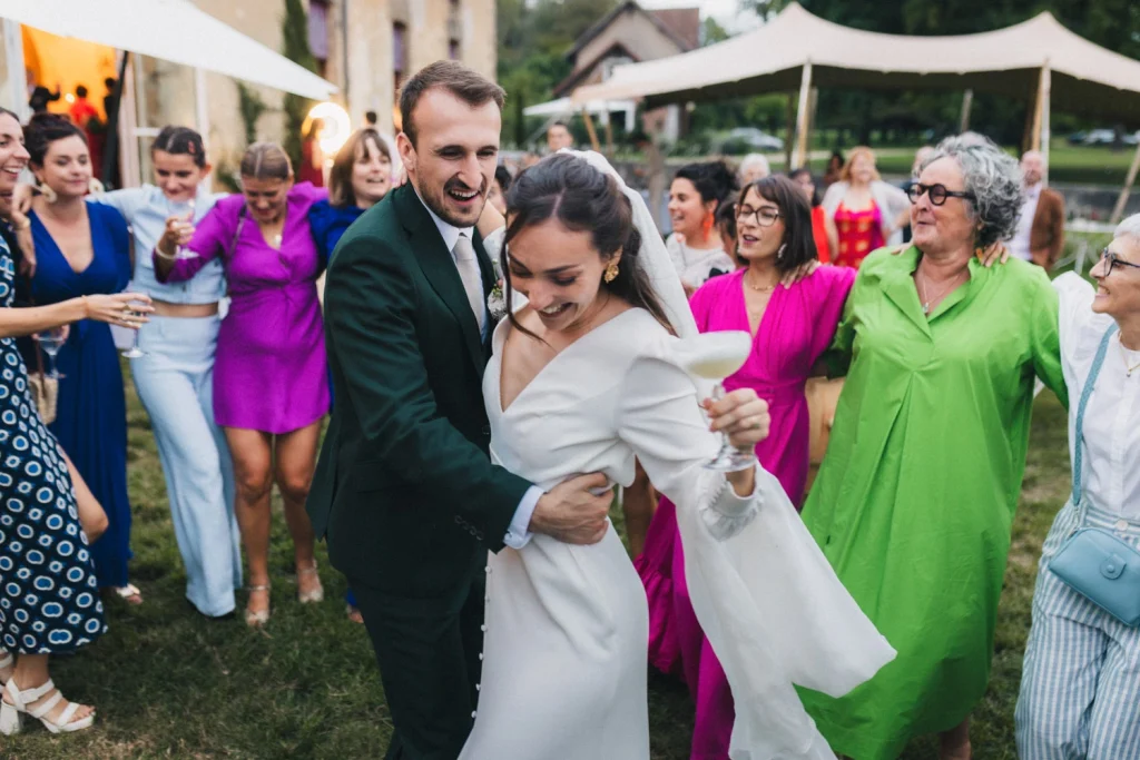 Cocktail de mariage où les mariés dansent au milieu de leurs invités dans une myriade de couleurs, immortalisé par une photographe mariage landes