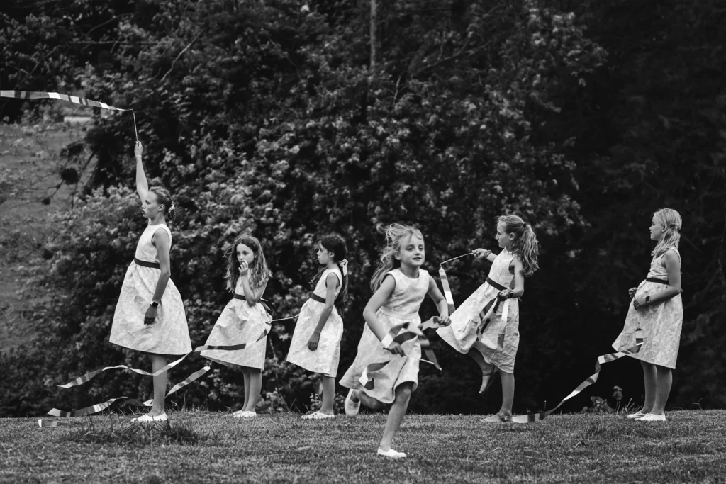 Pendant le cocktail, les enfants d'honneur en robes blanches jouent avec des rubans.