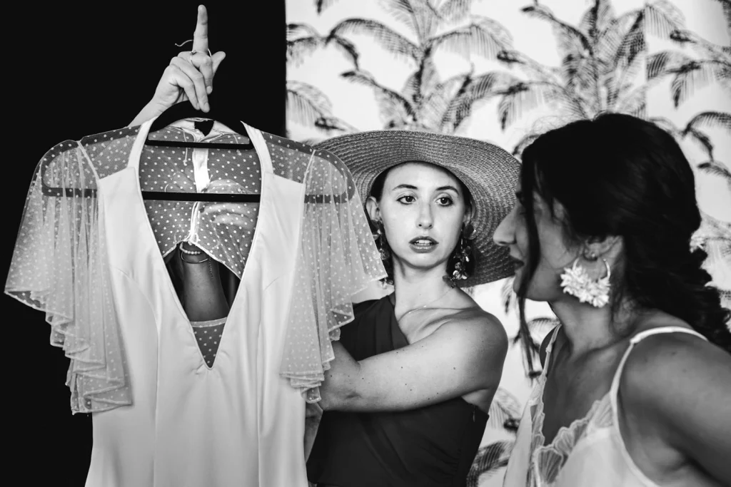 Les témoins apportent sa robe à la mariée pendant ses préparatifs au domaine Le Herre en Gironde.