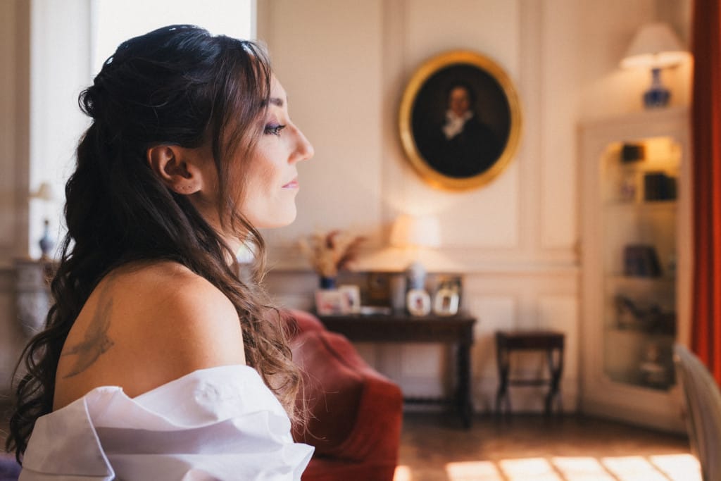 La mariée patiente, l'air mélancolique, de pouvoir enfiler sa robe avant de partir pour la cérémonie