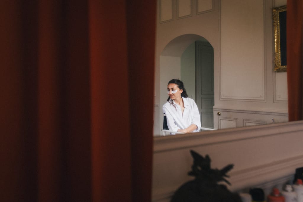 Reflet de la mariée dans un miroir pendant ses préparatifs dans le salon du château de Campet
