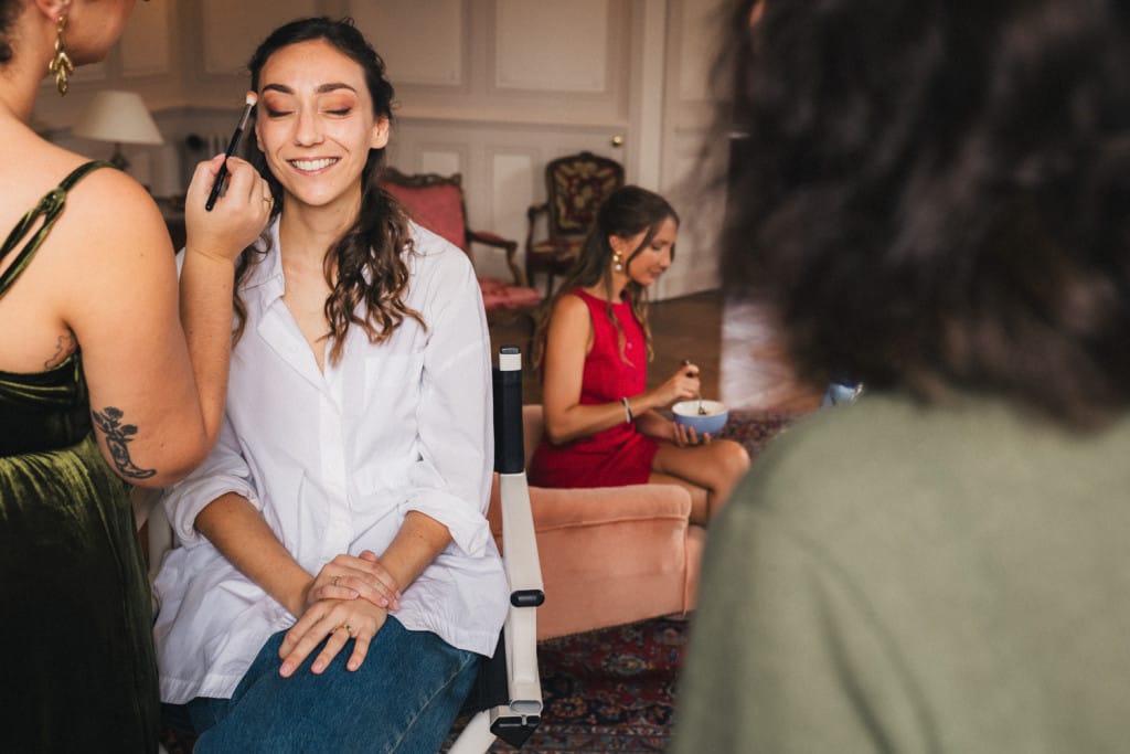 Pendant ses préparatifs, la mariée se fait maquiller dans le salon du château de Campet
