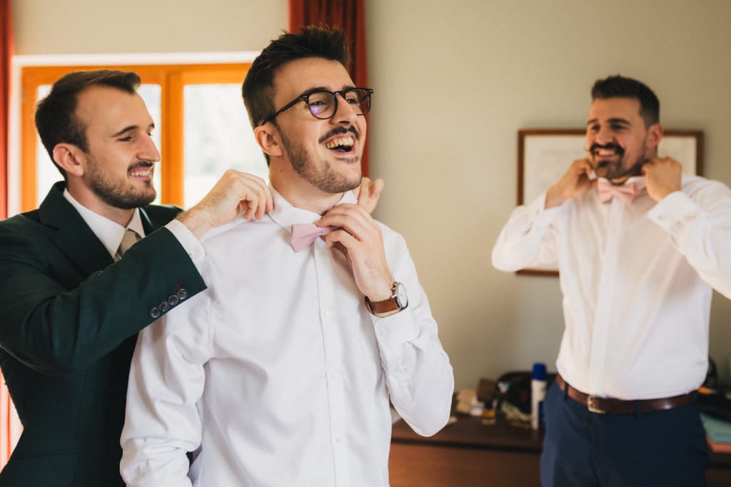 Le marié s'habille avec ses frères et les aide à enfiler leur noeud papillon, ils rient tous de bon coeur
