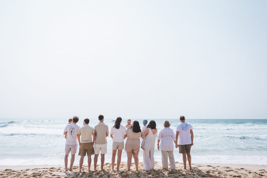 Une famille nombreuse regarde l'océan, sur une plage de Gironde. La photographe famille Landes les a pris de dos.