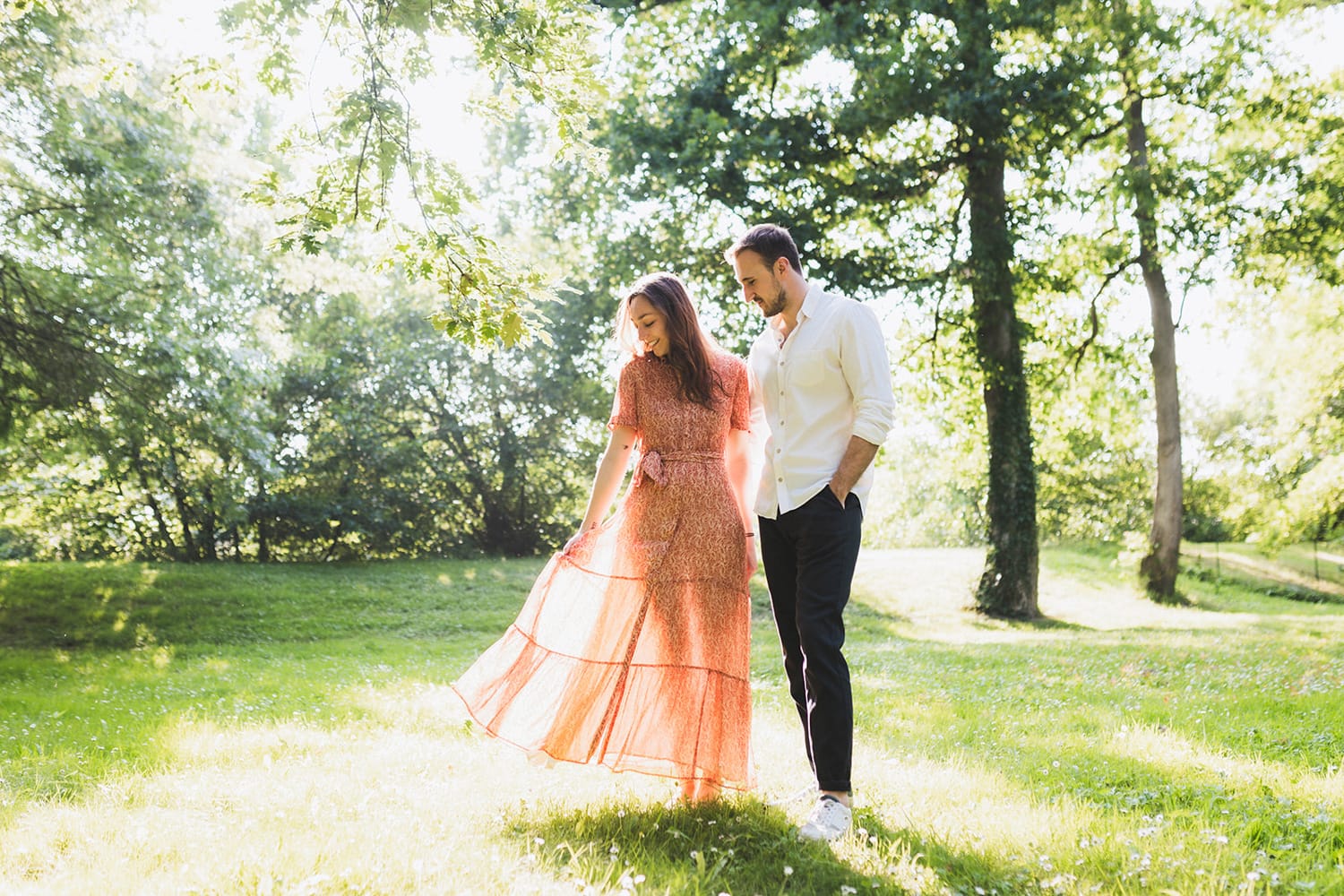 La future mariée joue avec sa robe dans les rayons du soleil lors d'une séance photo animée par une photographe landes