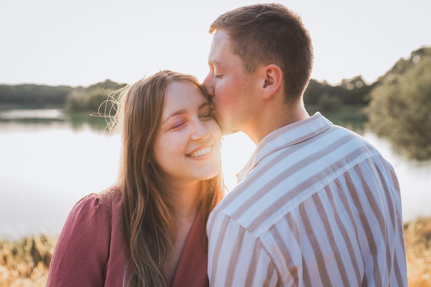 Le fiancé embrasse tendrement sa chérie sur la tempe